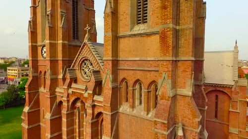 Aerial panning of an old Beautiful Church through the building, A clock on the Church and a cross at