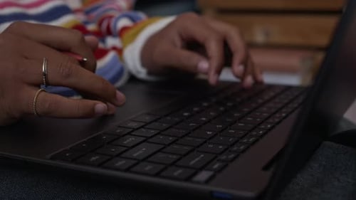Pessoa irreconhecível trabalhando no laptop sentada no chão