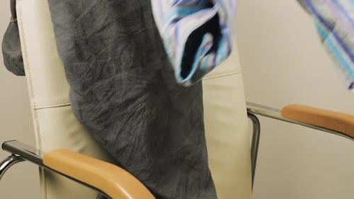 Various Clothing Piled on Modern White Chair