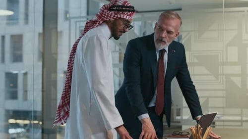 Intercultural Colleagues Using Laptop Discussing Business at Office