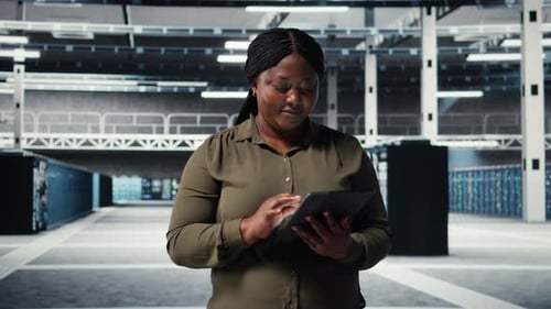 Программист центра обработки данных отслеживает показатели центра обработки данных на планшете