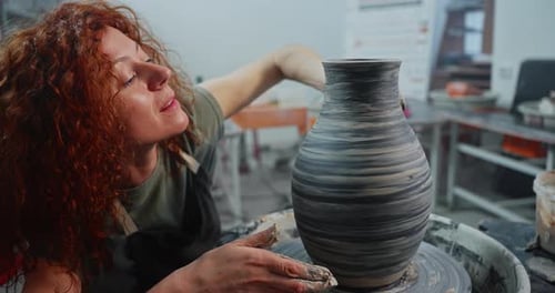 Woman Shapes Clay Pot on Pottery Wheel