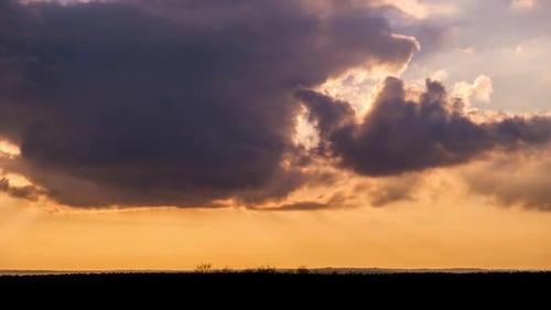 Timelapse of Dramatic Sunset with Sun Rays in the Sky Through Orange Clouds