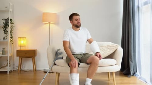 Man With Broken Leg and Arm Sitting Indoors