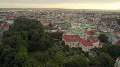 Aerial establishing shot of Cracow City with old Buildings in town during golden sunrise - Forest tr