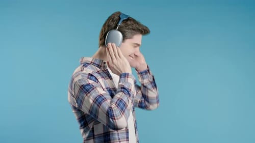 Brunette Positive Man Listening Music Dancing with Headphones Blue Studio