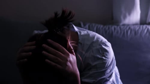 Distressed Woman Sits Alone in the Darkness