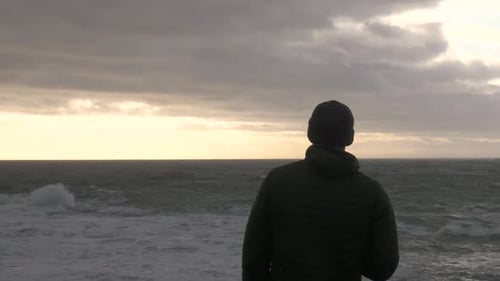 Depressed Man Overlooks Stormy Sea At Sunset