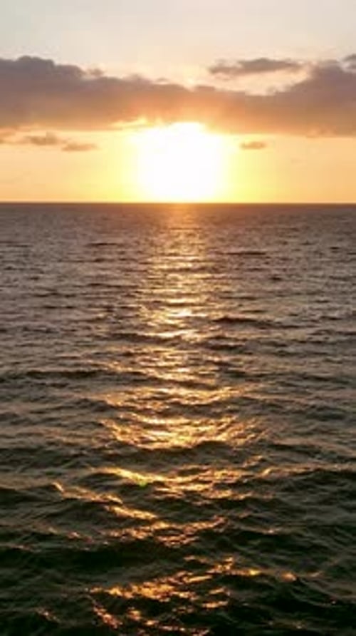 Vertical Video Sunset Serenade Aerial View of People Enjoying the Magic of a Beach