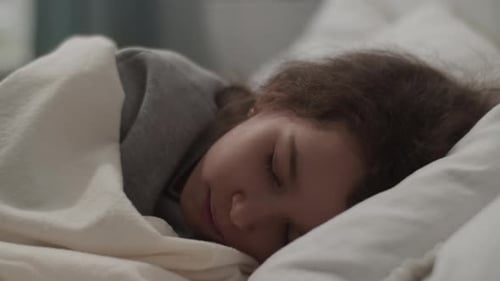 Child sleeping peacefully in a white bed