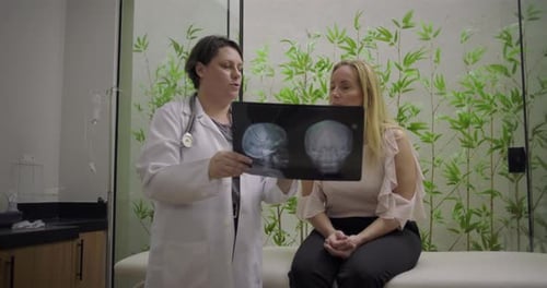 Female Doctor Explains Scan to Patient in Office