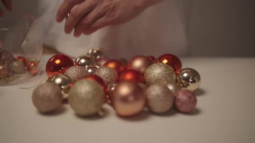 Colleción vibrante de adornos navideños con las manos de una persona irreconocible de cerca, que incluye