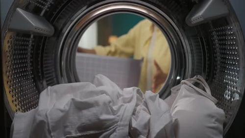 View From Inside the Washing Machine Young Couple Having an Argument While Doing Laundry