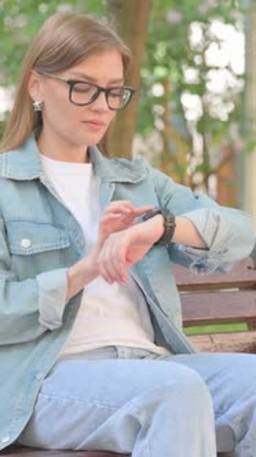 Vertical Video, Waiting Young Woman Checking Wrist Watch on Park Bench