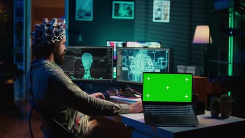 Engineer with EEG Headset on Merging with AI Green Screen Laptop