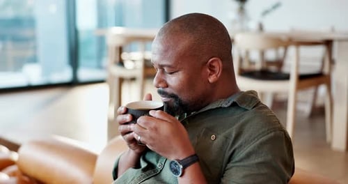 Man Enjoys Coffee on Couch in Apartment