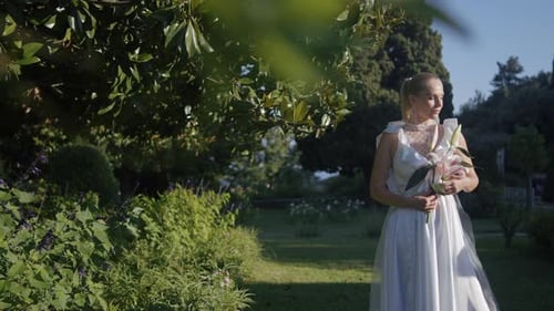 Posing Bride and Groom ActionYoung People in a Summer Park with Bright Flowers and Trees Pose in