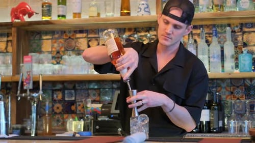 A Bartender Expertly Mixing Colorful Cocktails in an Elegantly Styled Bar Setting