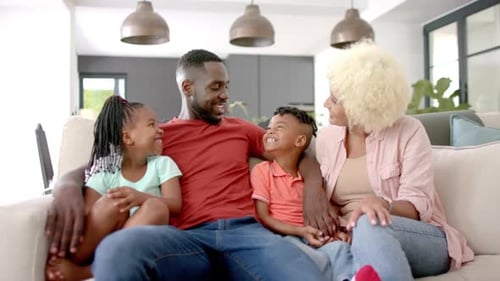 Happy Family Smiles on Sofa At Home
