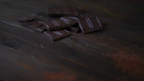 Dark Chocolate Chunks with Cocoa Powder on Wood