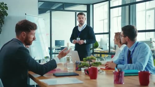 A Diverse Group Meets in a Modern Office Engaging in Teamwork