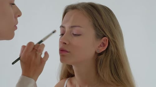 Makeup Artist Applying Eyeshadow to Model