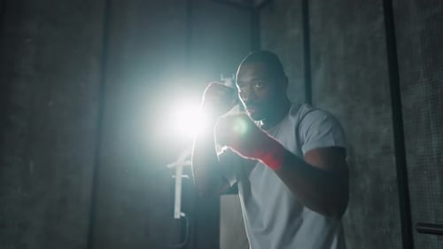Retrato de un boxeador agresivo en el gimnasio, afroamericano, centrado en el deporte, luchador sudado durante el boxeo