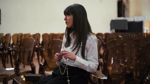 Woman Using Rosary To Pray In The Church