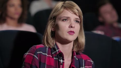 Woman Yawning in a Dark Movie Theater