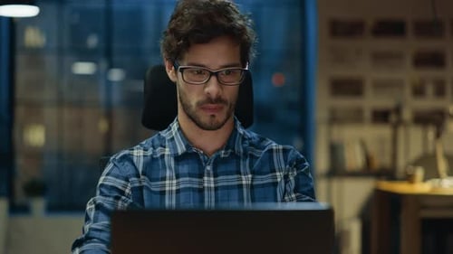 Portrait of the Handsome and Successful Young Creative Entrepreneur Working at His Desk Using Lapto