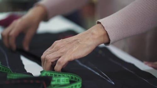 Clothes manufacturing process. Seamstress hands working on fashion designs