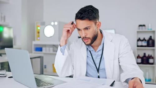 Focused Scientist Working at Laptop in Clean Lab