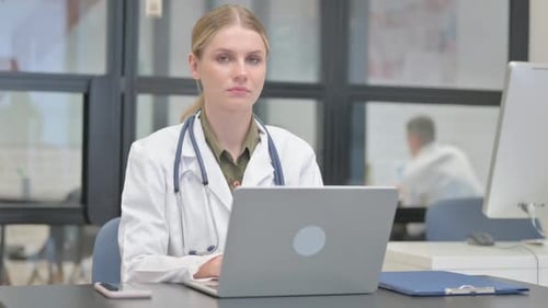 Young Female Doctor Smiling at Camera in Clinic