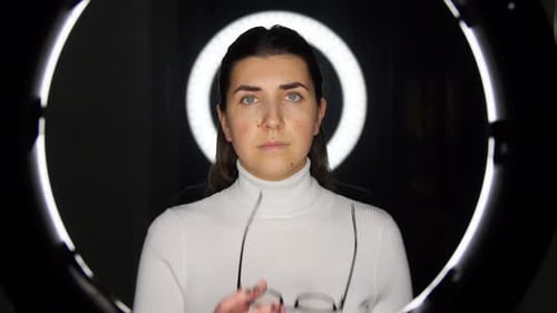 Woman With Ring Light Puts on Glasses