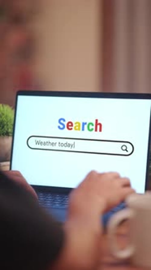 Hands Typing Weather Into a Computer Search