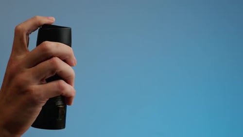 Young Man Applying Perfume to Skin in the Dark Close Up of Spraying Deodorant Luxury Perfume
