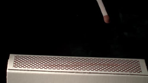 Close up of Match Igniting in Dark