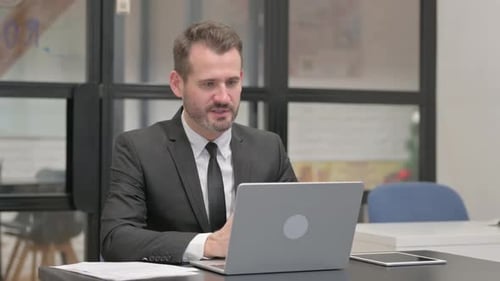 Businessman in Suit Having Video Call on Laptop