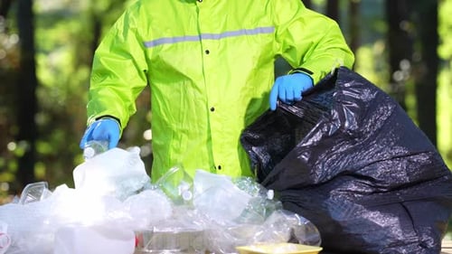 Los voluntarios retiran la basura para proteger la naturaleza. Las manos con guantes recolectan los desechos plásticos