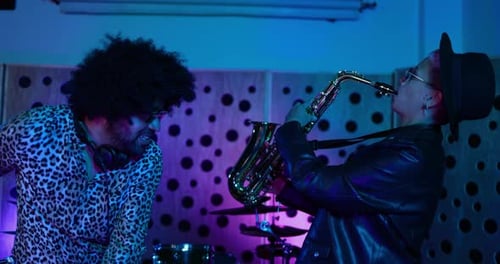 Young musicians dancing while mixing new album inside recording studio