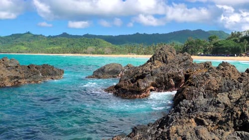 Waves Beat Against Big Rocks in the Ocean with Clear Water Concept of Nature