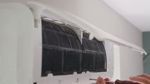 Repairing Dirty Air Conditioning Unit With Screwdriver