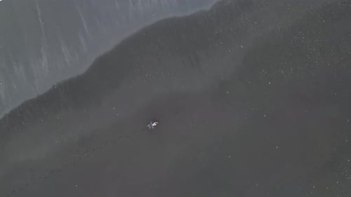 Lonely man walking on the beach of Iceland, Reynisdrangar, aerial