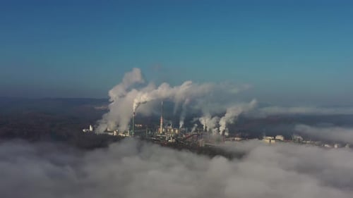 Massive Air Pollution From Coal Power Plant, Aerial View. Smoke Above Fog Under Clear Sky. Climate C
