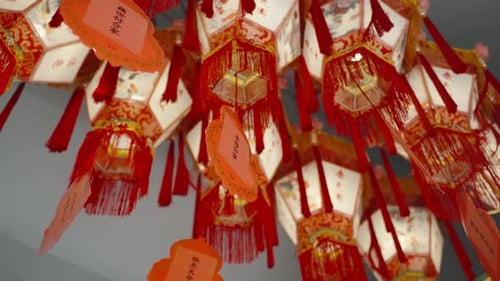 Close Up of Traditional Chinese Lanterns Illuminated in Temple Hanging Ceiling