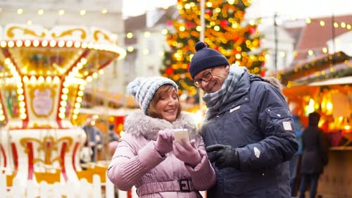 Couple looking at smartphone at Christmas market