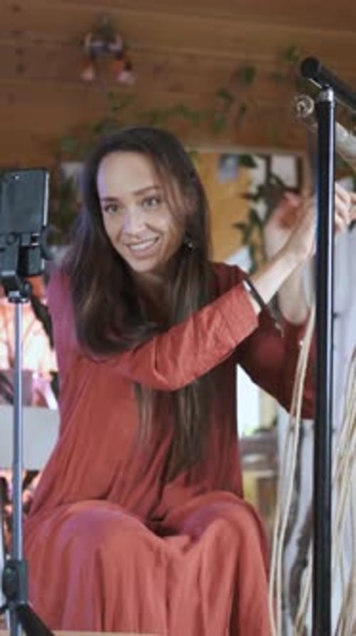 una mujer graba una lección en Vídeo por teléfono sobre tejer macramé, Vídeo vertical