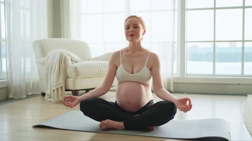 Pregnancy Prenatal Breathing Pregnant Woman with Big Belly Sitting in Lotus Pose on Yoga Matt at