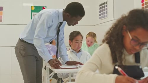 Teacher Helping Students in a Modern Classroom