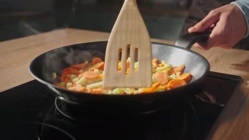 Stir Frying Vegetables in a Pan on Stove
